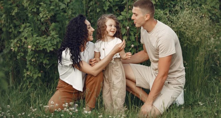 A joyful family enjoying time together in a lush green meadow, capturing love and bonding.